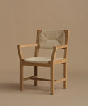 A vintage inspired dining chair with wood against a beige background.