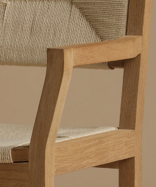 A close up of a  vintage inspired dining chair with wood against a beige background.