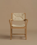 A vintage inspired dining chair with wood against a beige background.