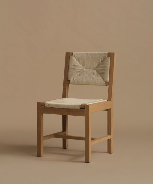 A warm oak dining chair against a beige background.