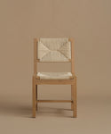 A warm oak dining chair against a beige background.