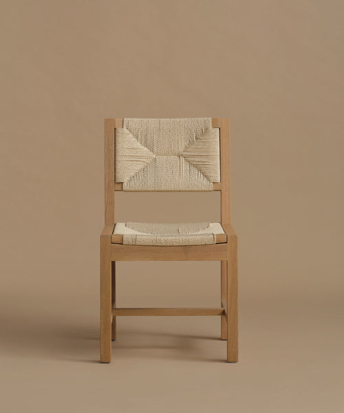 A warm oak dining chair against a beige background.