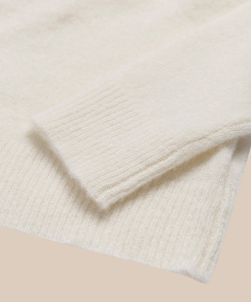 Close-up of the ribbed cuff and hem of the Murphy Cardigan in ivory, showcasing its soft texture and fitted knit against a neutral background.