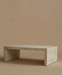 An ivory parchment coffee table with natural detailing against a beige background.