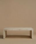 An ivory parchment coffee table with natural detailing against a beige background.