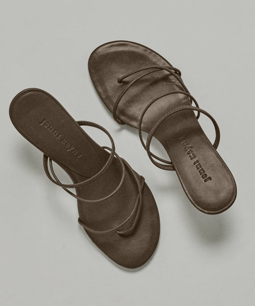 The Eve Heeled Sandal features brown, minimalist nappa leather straps and Jenna Lynn embossed on the insole, shown against a neutral background.