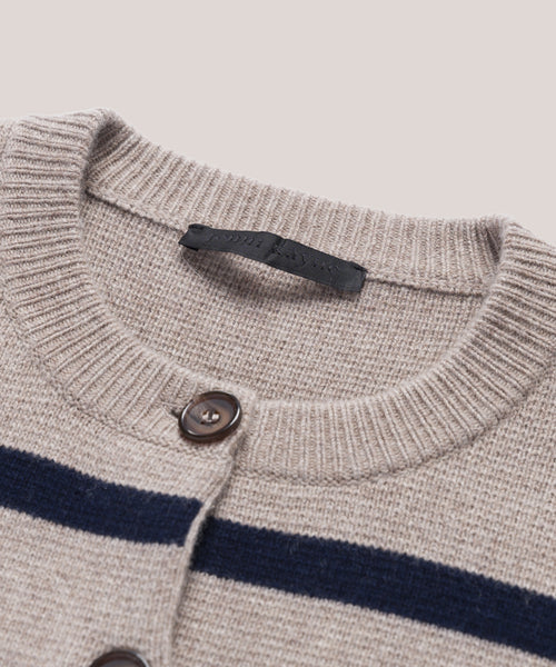 Close-up of the Cooper Cardigan, showing its structured silhouette, ribbed collar, dark buttons, two bold navy stripes across the taupe chest, and a black fabric label inside the collar.