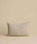 The Nell Boucle Lumbar Pillow, featuring a soft, textured beige fabric, is centered upright against a matching beige background.