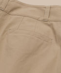 Close-up of the back pocket area of the Newport Trouser, featuring a single welt pocket, belt loop, and visible stitching on smooth beige cotton poplin fabric.