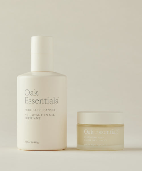 The Double Cleanse Duo by Oak Essentials is shown on a neutral background, featuring minimalist beige and gold packaging for an elegant, refined appearance.
