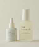 The Rescue Edit by Oak Essentials on a neutral background—minimalist bottles with clean white labels, featuring Ritual Oil for a luminous glow (dropper) and Balancing Mist with a spray top.