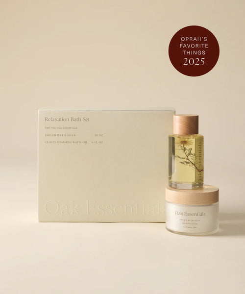 The Relaxation Bath Set includes hydrating bath oil, magnesium-infused soak, and comes in a cream box with wooden lids. A brown circular badge says “Oprah’s Favorite Things 2025.”.