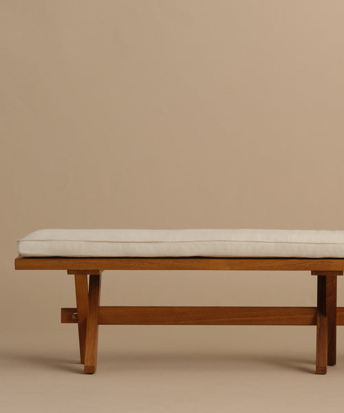 The Outdoor Garden Dining Bench features solid teak construction and a Tempotest fabric cushion, showcased against a simple beige background.