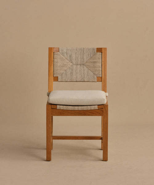 The Outdoor Montecito Dining Chair features solid teak, a woven ECOLENE geometric backrest, and a cushioned seat, displayed against a plain beige background.
