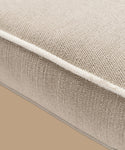 Close-up of the Outdoor Vista Chair Cushion in beige textured Italian fabric, featuring visible edge stitching, set against a plain light brown background.