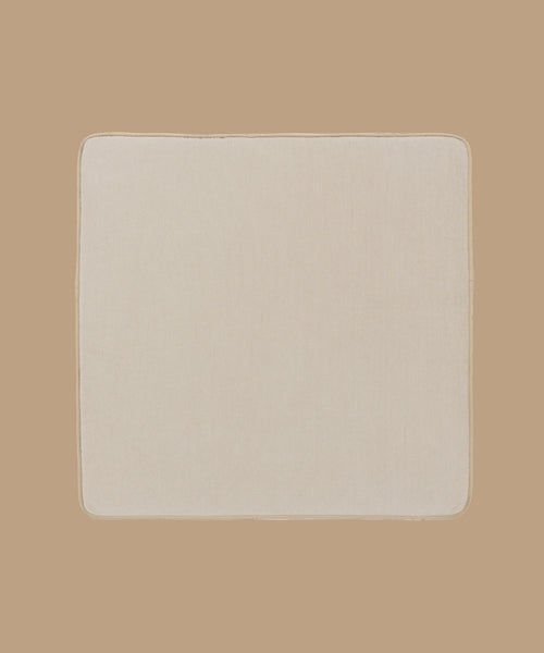 The Outdoor Vista Chair Cushion, square-shaped with rounded corners and crafted from beige Italian fabric, is displayed on a plain light brown background.