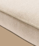 Close-up of the Outdoor Vista Chair Cushion—beige Italian textured fabric with visible edge stitching. From the elegant Vista Collection, perfect for outdoor seating and set against a plain tan background.