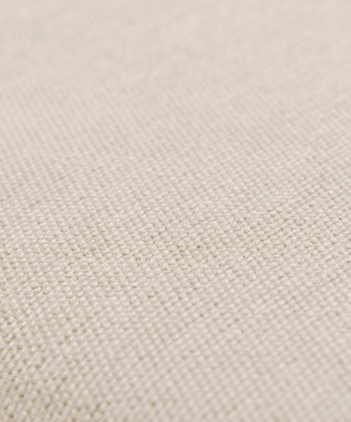 Close-up of a beige, textured fabric on the Outdoor Vista Chair Cushion, featuring a visible woven pattern and small, evenly spaced threads. The slightly rough surface offers a natural look, perfect for outdoor seating or Italian-inspired upholstery.