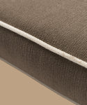 Close-up of the Outdoor Vista Chair Cushion, showcasing brown textured Italian fabric and white piping detail, set against a neutral beige background.