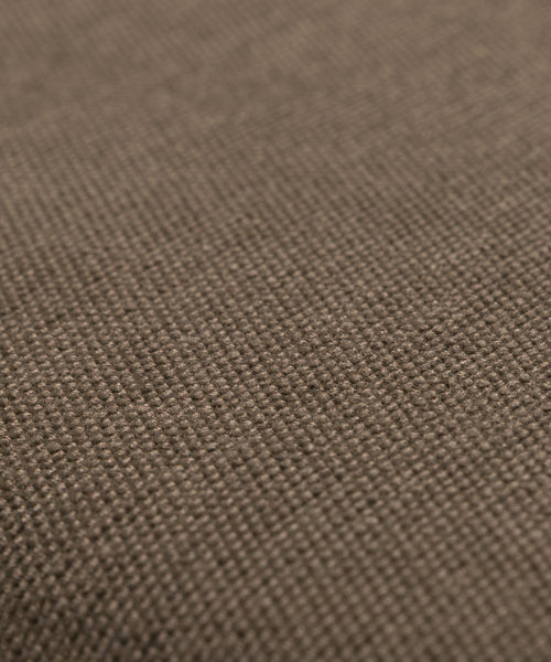 Close-up of the Outdoor Vista Chair Cushion shows its brown textured fabric with a tightly woven pattern and detailed fibers—an elegant choice for outdoor seating.