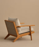 The Outdoor Vista Chair features a modern teak frame with angled legs, an ECOLENE woven backrest, and light beige Tempotest cushions, set against a neutral beige background.