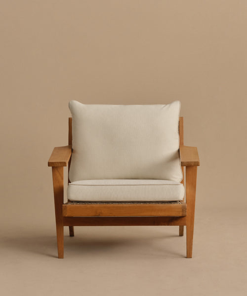 The Outdoor Vista Chair features wide armrests and visible wood grain, with light beige Tempotest fabric cushions. Its simple, modern design is showcased against a plain tan background.