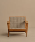 The Outdoor Vista Chair features wide armrests, angled legs, and a woven ECOLENE seat and backrest. Set on a plain beige background, this teak chair offers a sturdy, modern design ideal for stylish outdoor spaces.
