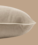 A close-up of the Outdoor Vista Lounge Cushion in beige linen with white piping, set against a matching beige background.