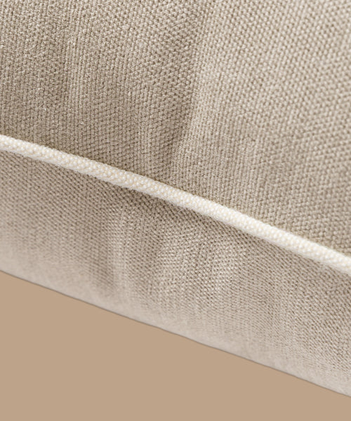 Close-up of the Outdoor Vista Lounge Cushion in textured beige Italian fabric with visible seam and piping, set against a matching beige background. From the elegant Vista Collection.