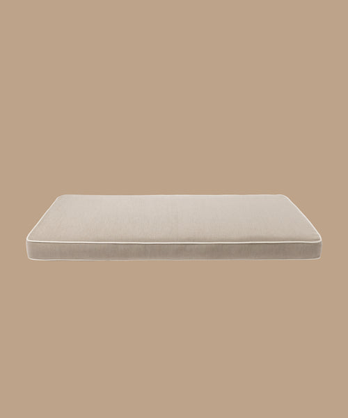 The Outdoor Vista Sofa Cushion is a rectangular beige outdoor cushion with white piping, crafted from premium Italian fabric and displayed against a solid light brown background.