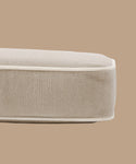 A close-up of the Outdoor Vista Sofa Cushion, beige and rectangular with white piping, made from premium Italian fabric, shown against a solid light brown background.