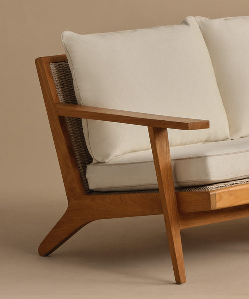 A close-up of the Outdoor Vista Sofa Cushion, featuring light beige Italian fabric and a woven backrest, set against a neutral background. Part of the elegant Vista Collection.