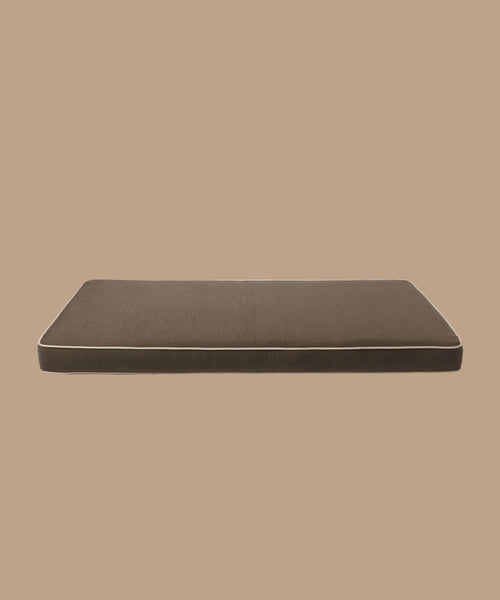 The Outdoor Vista Sofa Cushion is a rectangular brown cushion with light piping, made from fine Italian fabric and displayed against a solid beige background.