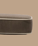 A close-up side view of the Outdoor Vista Sofa Cushion, a brown rectangular cushion with beige piping, made from Italian fabric and set against a plain beige background.