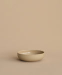 The Pacific Breakfast Bowl, crafted from beige stoneware, rests on a matching beige surface with a plain beige background.
