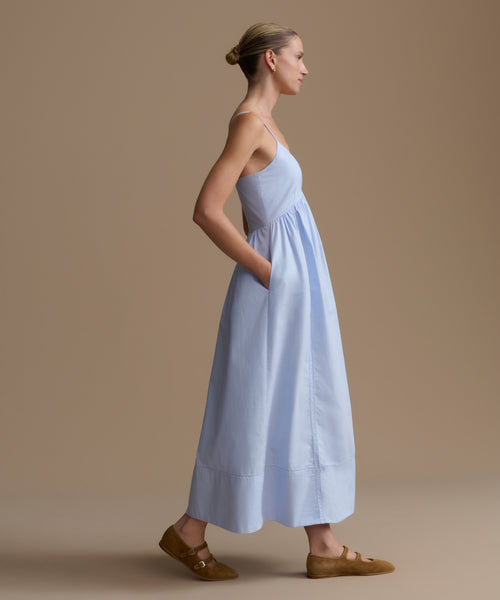 Woman wearing a light blue dress against a beige background