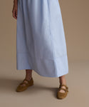 Light blue dress worn by a woman on a beige background