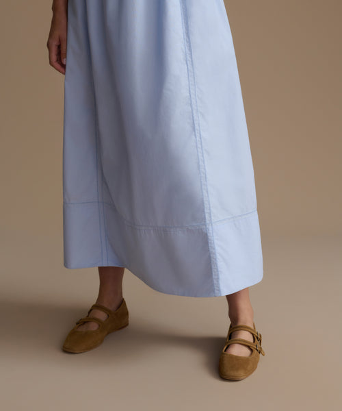 Light blue dress worn by a woman on a beige background