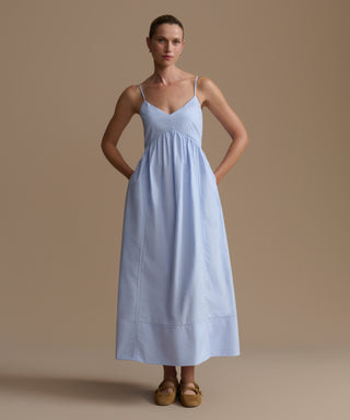 Woman wearing a light blue dress against a beige background