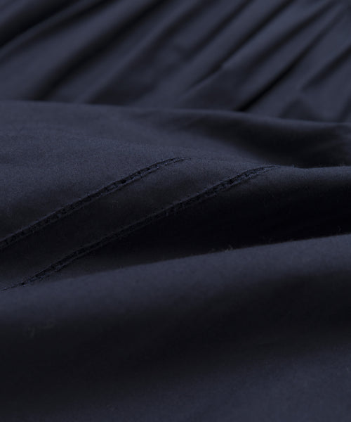 Close-up of dark navy blue Italian washed poplin fabric with visible stitching and gentle folds, offering a soft, smooth texture—ideal for the Peninsula Dress or other breezy sundress styles.