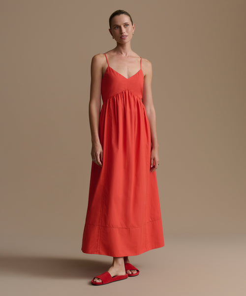 Woman wearing a red dress against a beige background