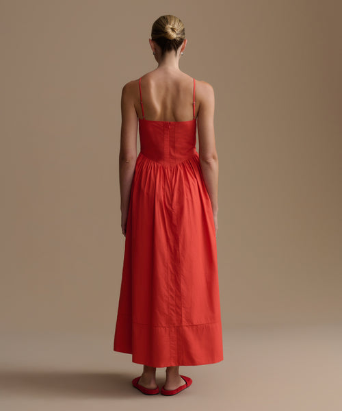 Woman wearing a red dress on a beige background