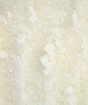 Close-up of coarse, white granules in Perfecting Body Scrub, featuring an uneven crystalline texture—ideal for exfoliating and hydrating skincare rituals.