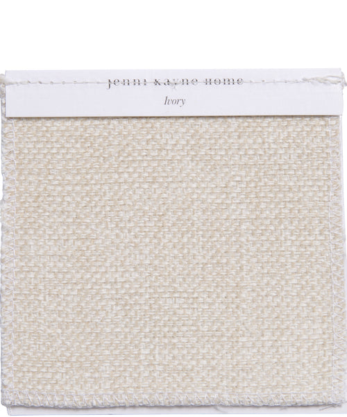 A square Fabric Swatch Performance Ivory displays a woven texture in creamy ivory, visible edge stitching, and a white paper label—ideal for use with the Outdoor Brentwood Ottoman.