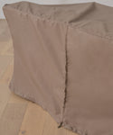 A close-up of the Outdoor Vista Sofa Cover in brown, draped over a rectangular object on a light wood floor. The cover has a visible seam and zipper along one edge, providing waterproof protection for patio furniture.