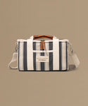 Striped bag with a visible brand label on a beige background
