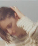 Thumbnail for video: Woman in a striped shirt and shorts standing on a beach.