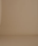 Thumbnail for video: A woman in side profile wearing a black ribbed mock-neck knit sweater and a dark pleated skirt, set against a solid warm beige studio background.