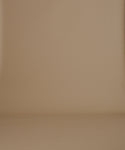 Thumbnail for video: A woman stands against a plain warm beige studio background wearing a dark brown long-sleeve knit sweater and a matching dark brown pleated maxi skirt, with slip-on shoes.