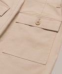 Close-up of the Ranger Trouser in beige, featuring a large side pocket with flap and button closure, detailed stitching, and part of the waistband—a classic design with practical style.